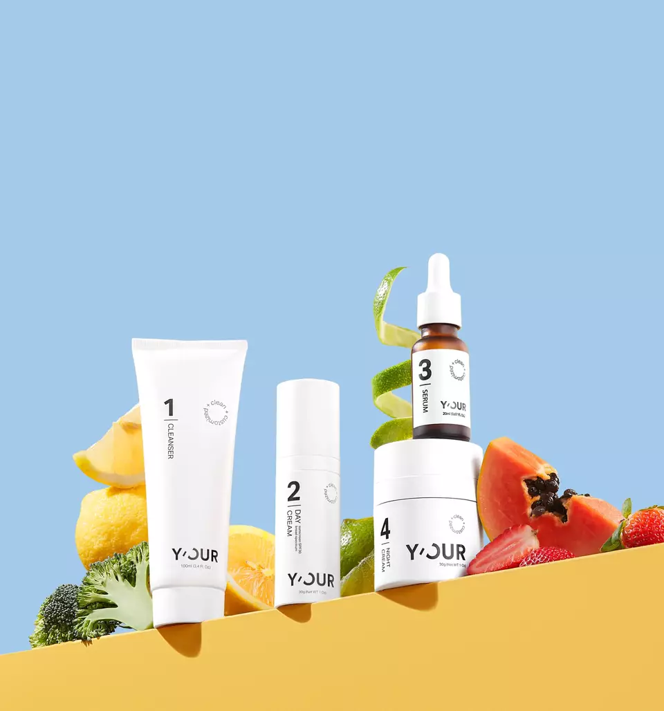 4-step personalized skincare set featuring a cleanser, day cream, serum, and night cream, displayed with fresh fruits and vegetables